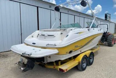 Slide: The Image of 2004 Chaparral 230 SSi boat on trailer, white and yellow, parked outdoors. - 6