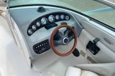 Slide: The Image of 2004 Chaparral 230 SSi boat dashboard with wood-trimmed steering wheel and instrument panel. - 8