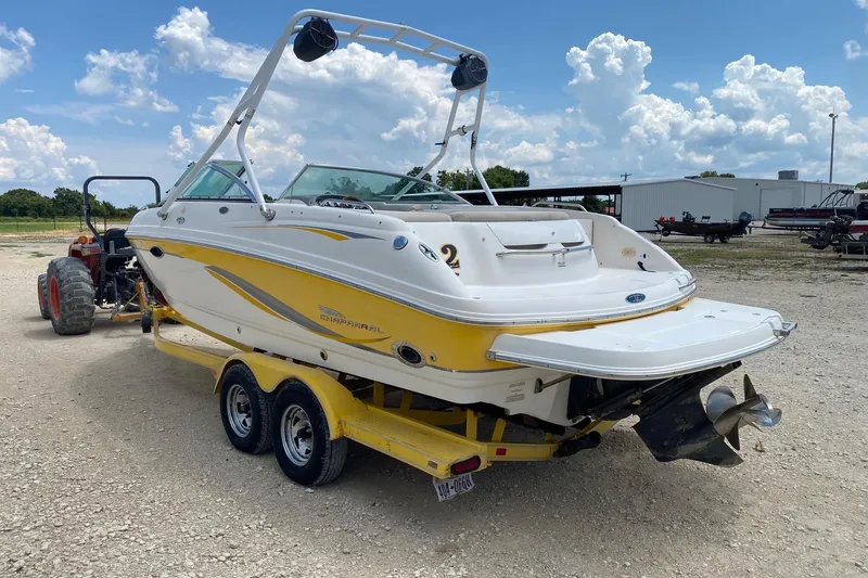 Slide: The Image of 2004 Chaparral 230 SSi boat on trailer, yellow and white design, parked outdoors. - 4