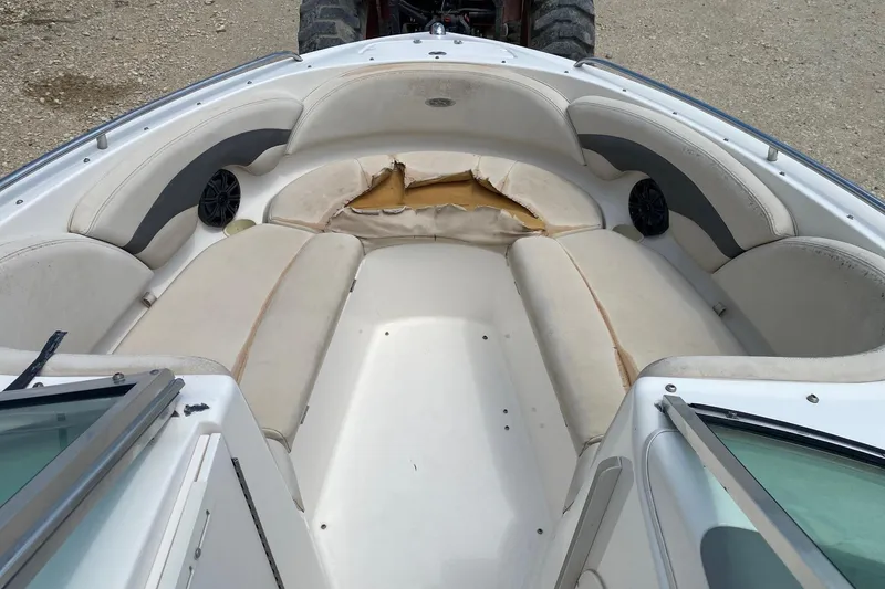 Slide: The Image of 2004 Chaparral 230 SSi boat interior with worn seating and visible damage. - 8