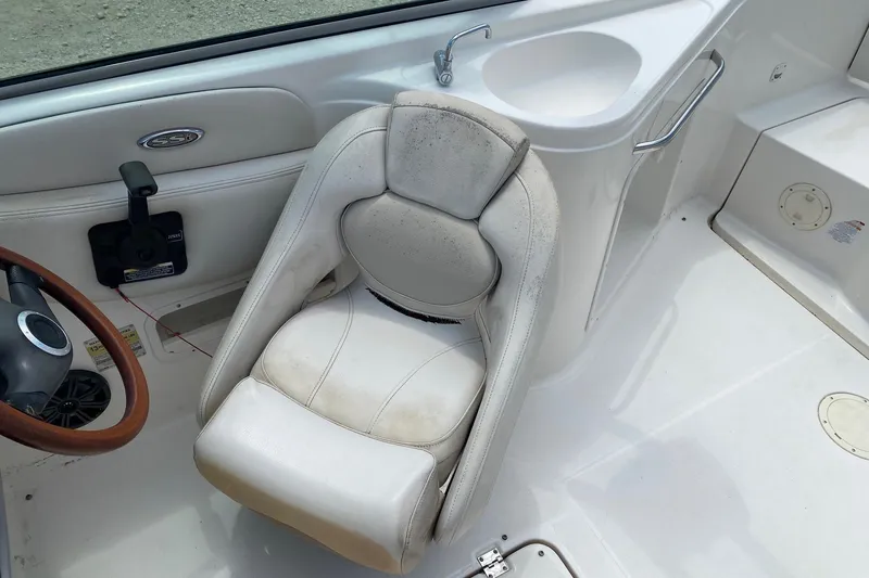 Slide: The Image of 2004 Chaparral 230 SSi boat interior with white captain's seat and steering wheel. - 9