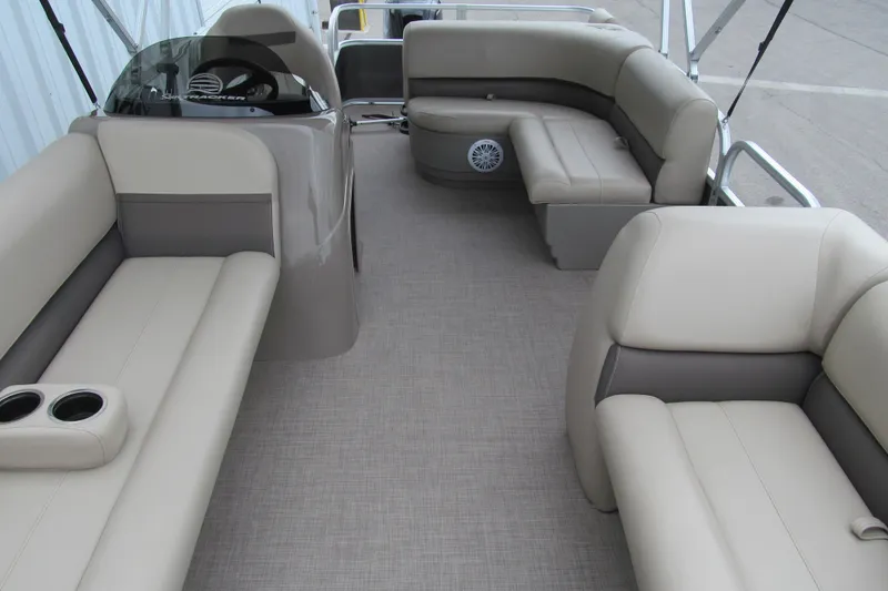 Slide: The Image of 2023 Sun Tracker Party Barge 18 DLX interior with beige seating and cup holders. - 8