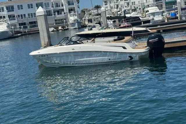 The Image of 2023 Bayliner VR5 Bowrider OB docked in a marina, surrounded by water and boats. - 0