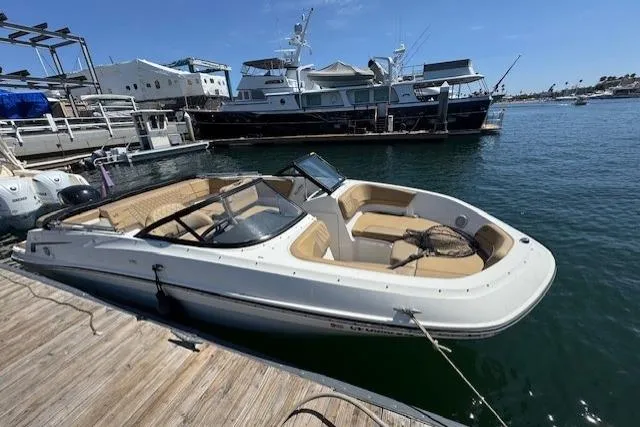 Slide: The Image of 2023 Bayliner VR5 Bowrider OB docked at marina, sunny day, calm waters. - 1