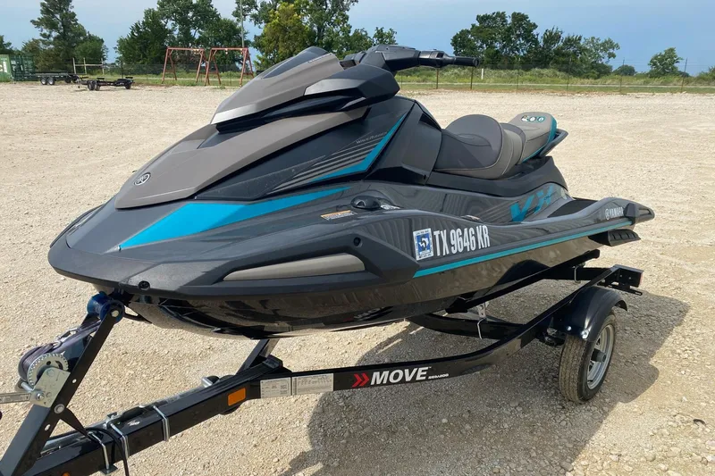 Slide: The Image of 2023 Yamaha WaveRunner VX Cruiser on trailer, parked on gravel lot. - 2