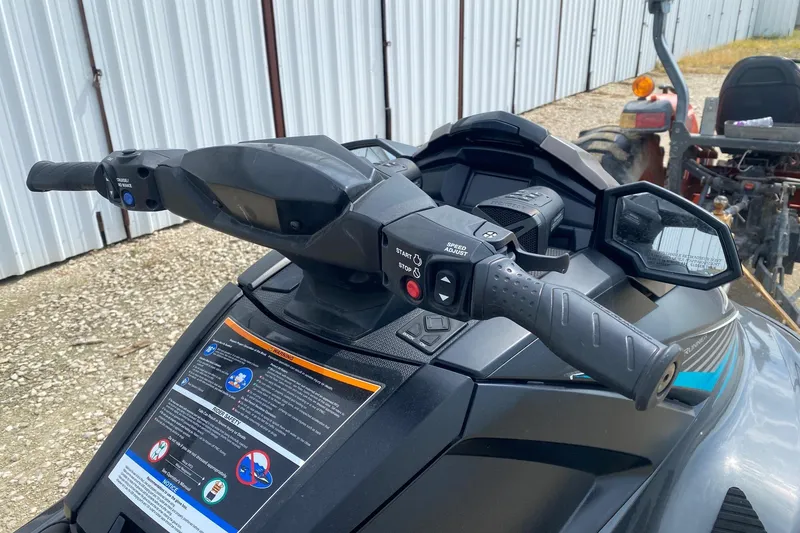 Slide: The Image of 2023 Yamaha WaveRunner VX Cruiser handlebars and controls, parked near a metal building. - 6