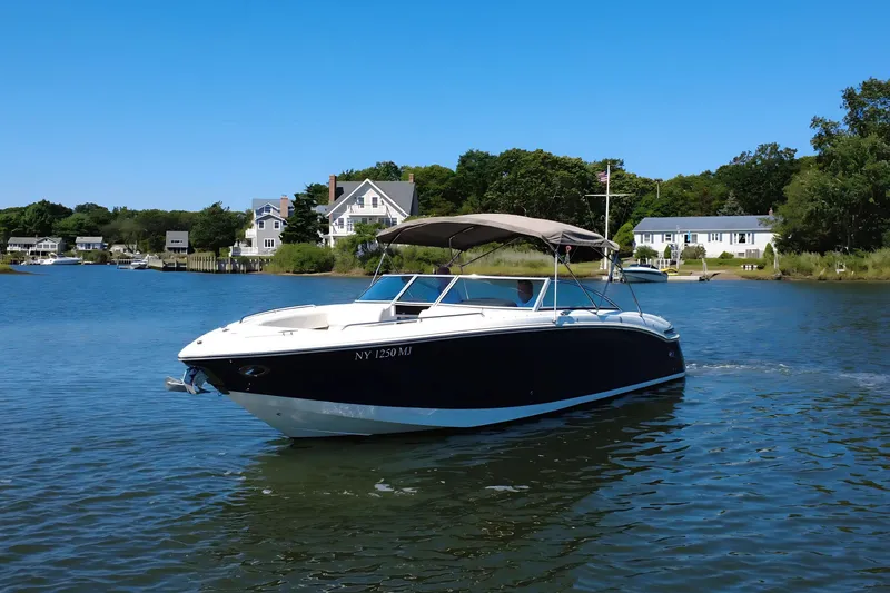 Slide: The Image of 2012 Cobalt 296 boat cruising on a scenic lake with waterfront homes. - 1