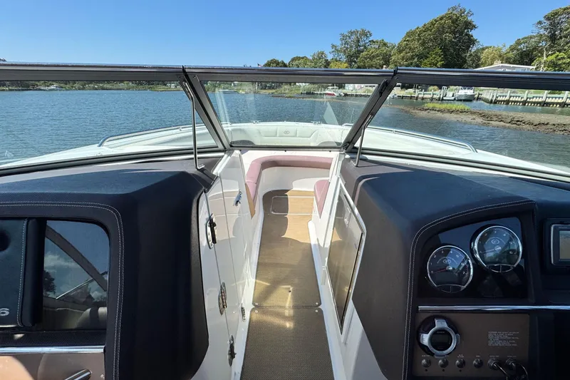 Slide: The Image of 2012 Cobalt 296 boat interior with dashboard, open windshield, and scenic water view. - 22