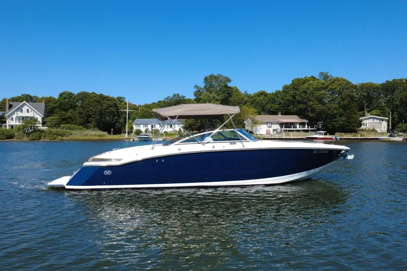 Slide: The Image of 2012 Cobalt 296 boat on calm water with houses and trees in the background. - 3