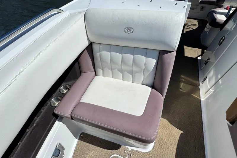 Slide: The Image of 2012 Cobalt 296 boat seat with white and purple upholstery, featuring cup holders. - 30