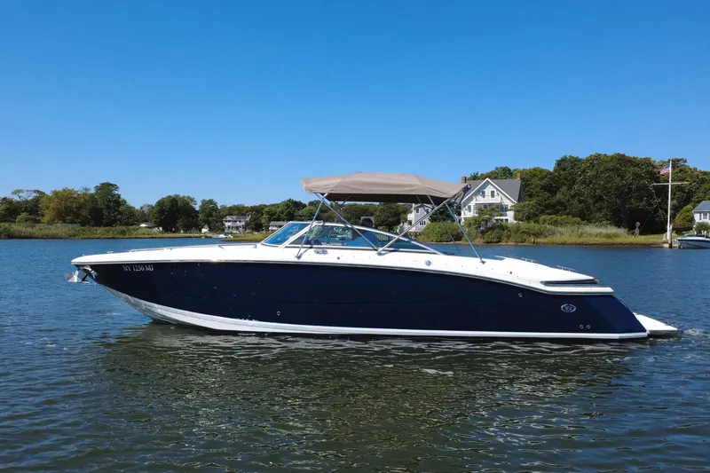 Slide: The Image of 2012 Cobalt 296 boat on calm water with houses in the background. - 4