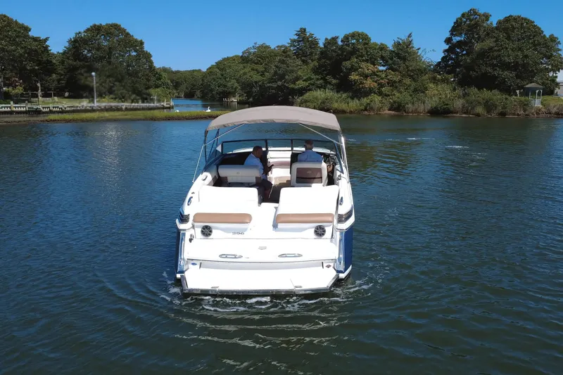 Slide: The Image of 2012 Cobalt 296 boat cruising on a serene lake with lush greenery. - 6