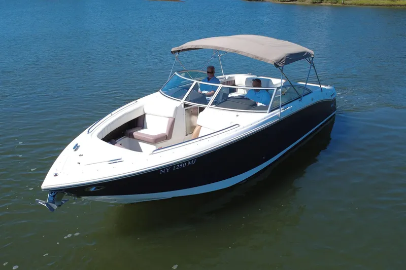 Slide: The Image of 2012 Cobalt 296 boat cruising on a calm lake with two passengers. - 9