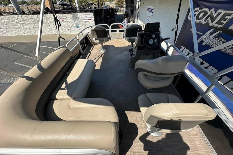 Slide: The Image of 2022 Sun Tracker Bass Buggy 18 DLX pontoon boat interior with beige seating and steering console. - 26