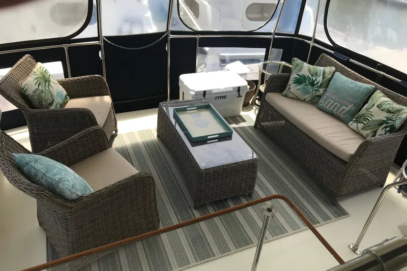 Slide: The Image of 1988 Tollycraft 40 Sundeck Motor Yacht interior with wicker furniture and tropical cushions. - 12