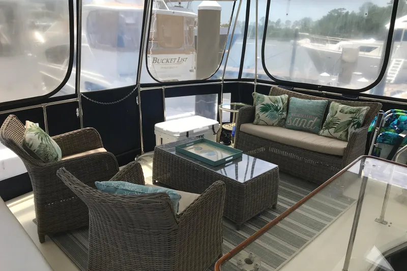 Slide: The Image of 1988 Tollycraft 40 Sundeck Motor Yacht interior with wicker furniture and tropical decor. - 14