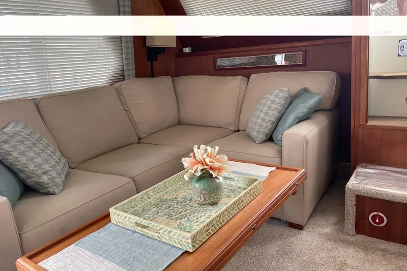 Slide: The Image of Interior of 1988 Tollycraft 40 Sundeck Motor Yacht with beige sofa and decorative pillows. - 15