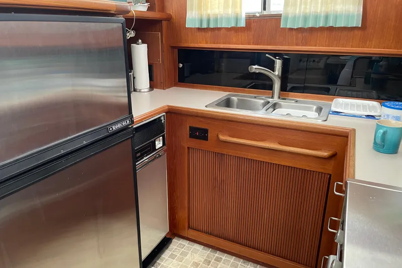 Slide: The Image of 1988 Tollycraft 40 Sundeck Motor Yacht kitchen with stainless steel appliances and wooden cabinetry. - 29