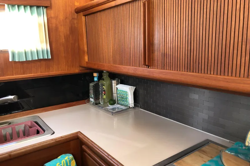 Slide: The Image of 1988 Tollycraft 40 Sundeck Motor Yacht kitchen with wood cabinetry and modern backsplash. - 30