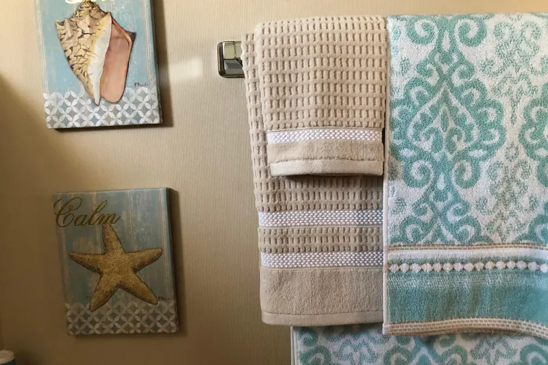 Slide: The Image of Nautical-themed bathroom decor with towels and seashell artwork on a 1988 Tollycraft yacht. - 41