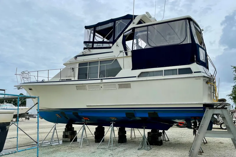 Slide: The Image of 1988 Tollycraft 40 Sundeck Motor Yacht on dry dock, featuring blue and white exterior. - 6