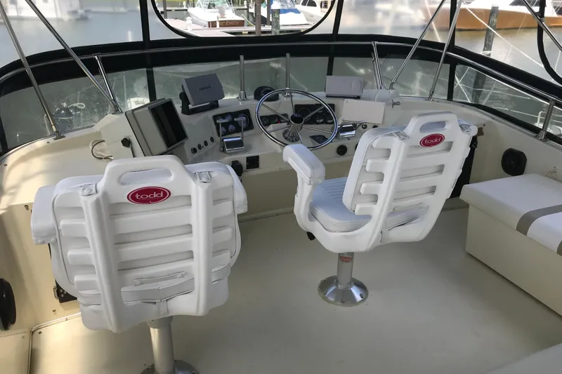 Slide: The Image of 1988 Tollycraft 40 Sundeck Motor Yacht helm with white Todd chairs and navigation equipment. - 8