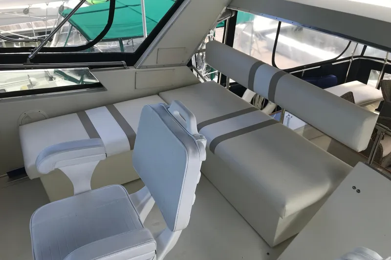 Slide: The Image of 1988 Tollycraft 40 Sundeck Motor Yacht interior with white seating and windows. - 9