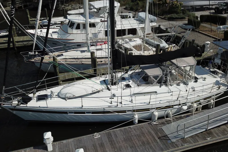 Slide: The Image of 1984 Tayana 55 sailboat docked at a marina, surrounded by other vessels. - 2