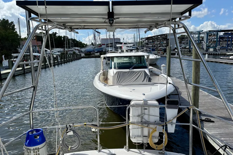 Slide: The Image of Sailboat docked at marina, Tayana 55 model, 1984, with clear skies and surrounding boats. - 21