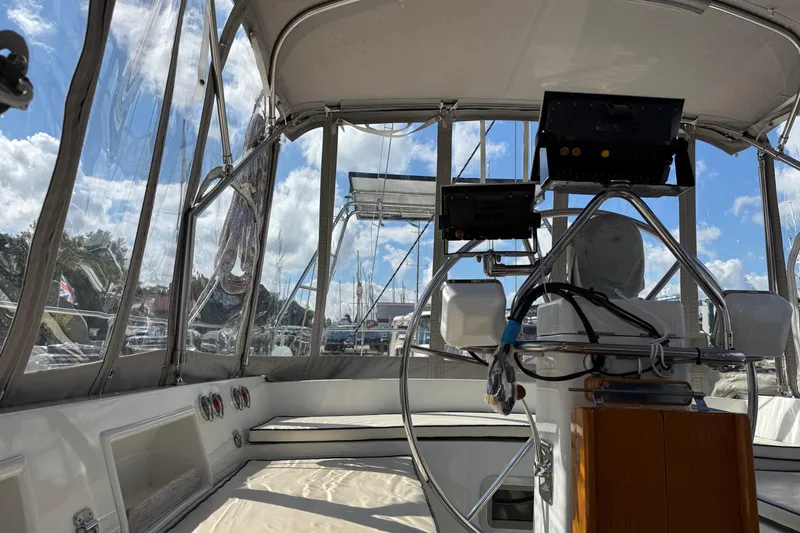 Slide: The Image of Interior view of 1984 Tayana 55 sailboat cockpit with steering wheel and navigation equipment. - 25