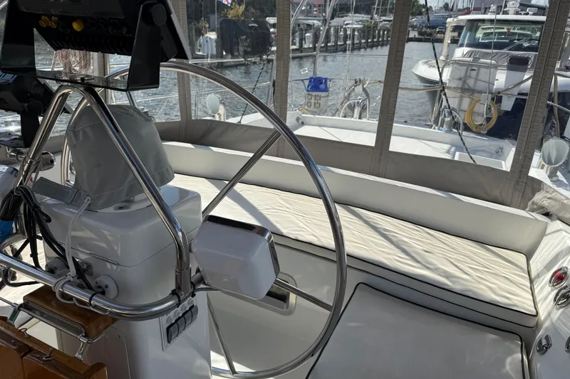 Slide: The Image of Cockpit of 1984 Tayana 55 sailboat with steering wheel and cushioned seating. - 26