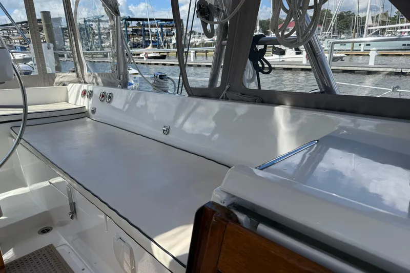 Slide: The Image of Cockpit of 1984 Tayana 55 sailboat docked at marina, featuring seating and helm. - 27