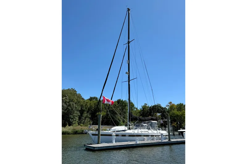 Slide: The Image of 1984 Tayana 55 sailboat docked with Canadian flag, clear blue sky background. - 3