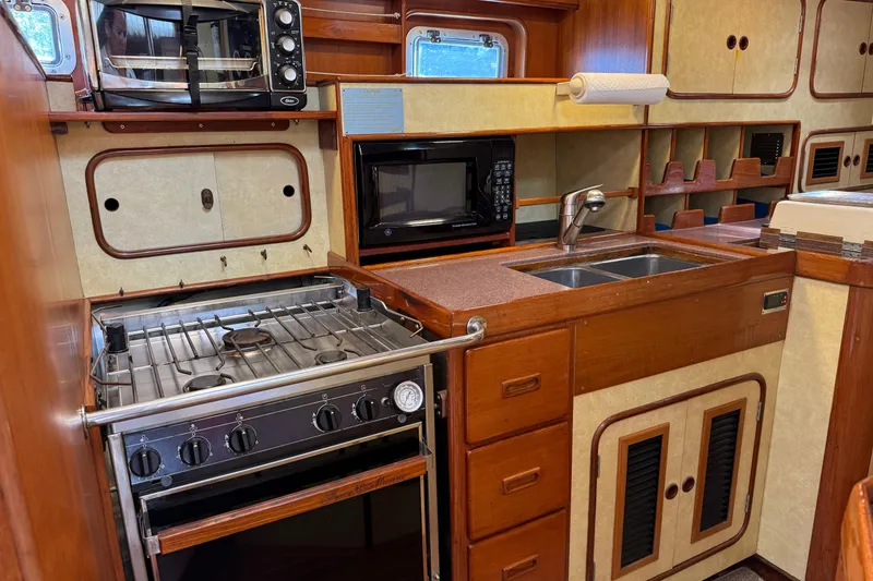 Slide: The Image of Galley kitchen in 1984 Tayana 55 yacht with stove, microwave, and sink. - 33