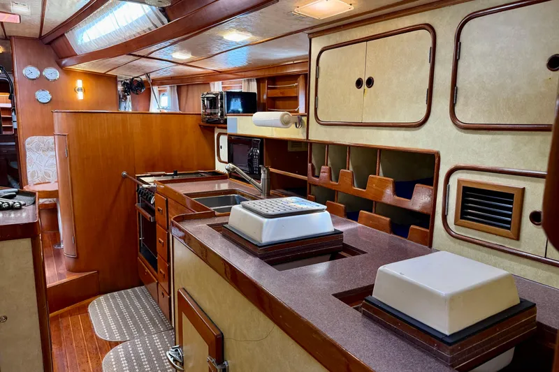 Slide: The Image of Interior of 1984 Tayana 55 yacht with wooden cabinetry and modern kitchen amenities. - 35