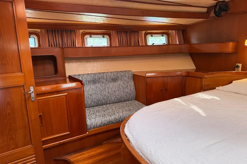 Slide: The Image of Luxurious 1984 Tayana 55 yacht interior with wood paneling and cozy seating area. - 38