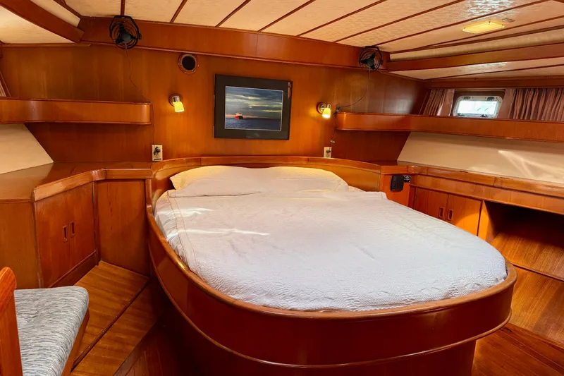 Slide: The Image of Luxurious wooden cabin interior of 1984 Tayana 55 yacht with cozy bed and ambient lighting. - 39