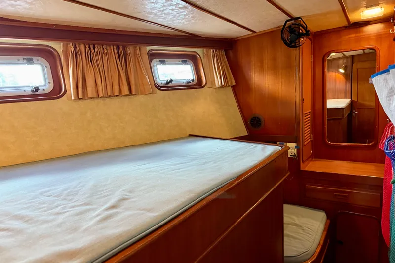 Slide: The Image of Cozy cabin interior of 1984 Tayana 55 yacht with wooden furnishings and porthole windows. - 43