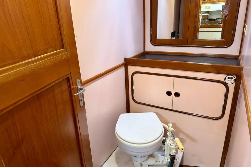 Slide: The Image of 1984 Tayana 55 yacht bathroom with wooden cabinetry and marine toilet. - 46
