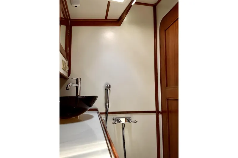 Slide: The Image of Bathroom interior of 1984 Tayana 55 yacht with modern sink and wooden accents. - 49