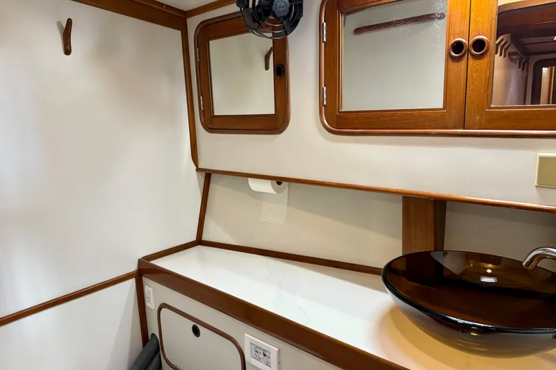 Slide: The Image of 1984 Tayana 55 yacht interior with wooden cabinets and modern glass sink. - 50