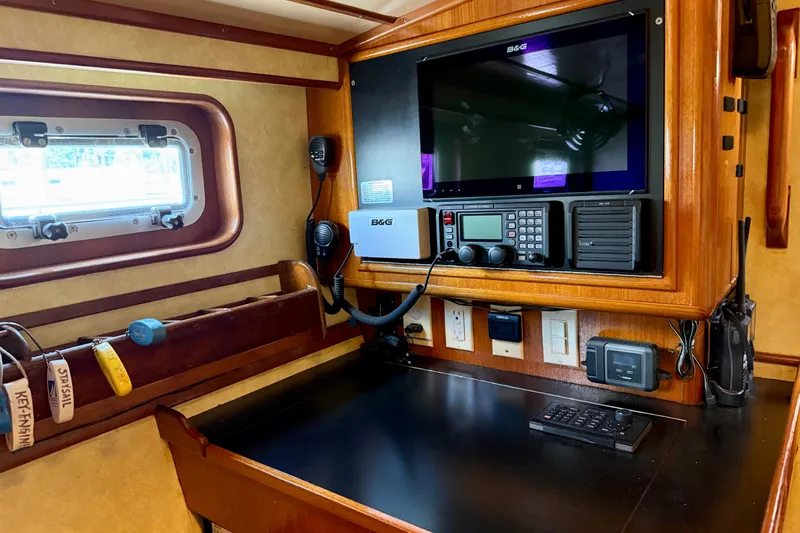 Slide: The Image of Navigation station on 1984 Tayana 55 yacht with modern equipment and wood finish. - 52