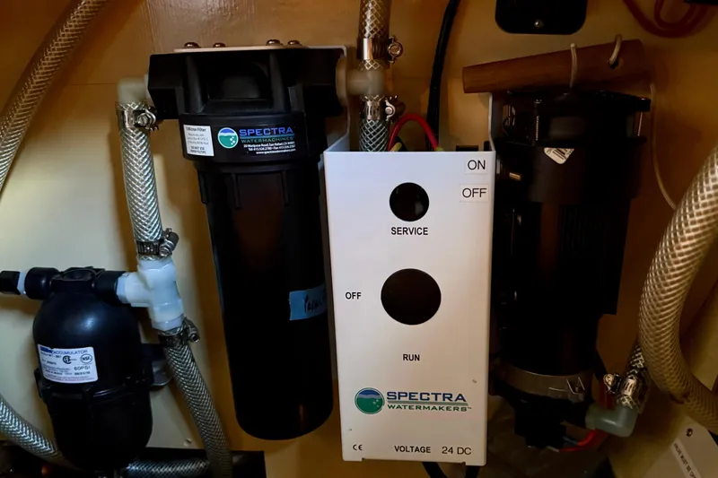 Slide: The Image of Spectra watermaker system in a 1984 Tayana 55 yacht, featuring control panel and filters. - 54