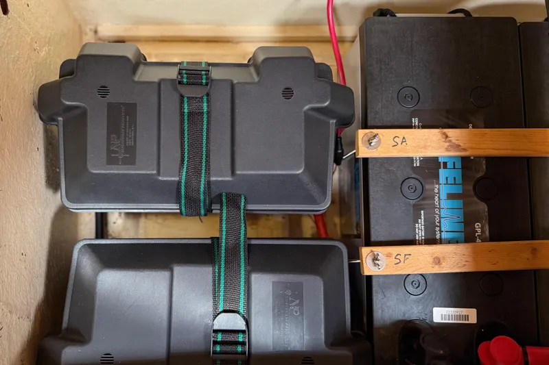 Slide: The Image of Battery compartment of a 1984 Tayana 55 yacht, featuring secured battery boxes and wiring. - 56