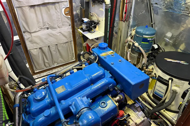 Slide: The Image of Engine room of a 1984 Tayana 55 yacht with blue machinery and equipment. - 58