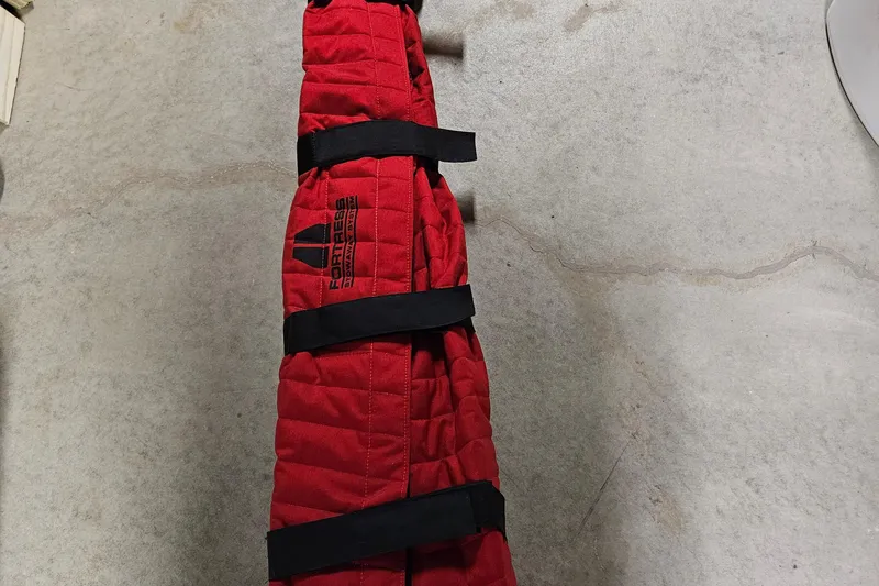 Slide: The Image of Red padded cover with black straps on a concrete floor, labeled "Fortress." - 59