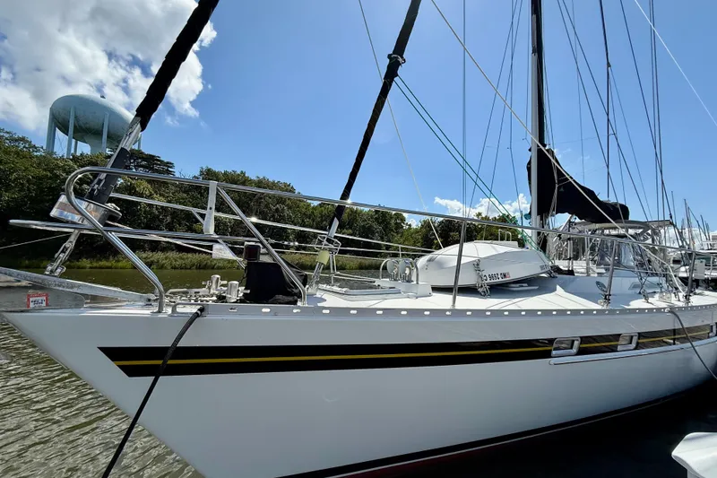 Slide: The Image of 1984 Tayana 55 sailboat docked, featuring sleek design and stainless steel railings. - 6