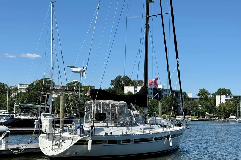Slide: The Image of 1984 Tayana 55 sailboat docked in a marina, clear blue sky background. - 8