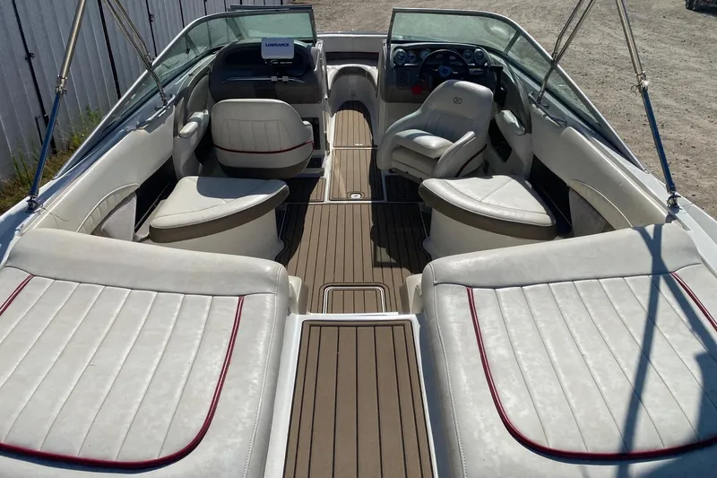 Slide: The Image of 2004 Crownline 250 CR boat interior with white seating and wood flooring. - 10