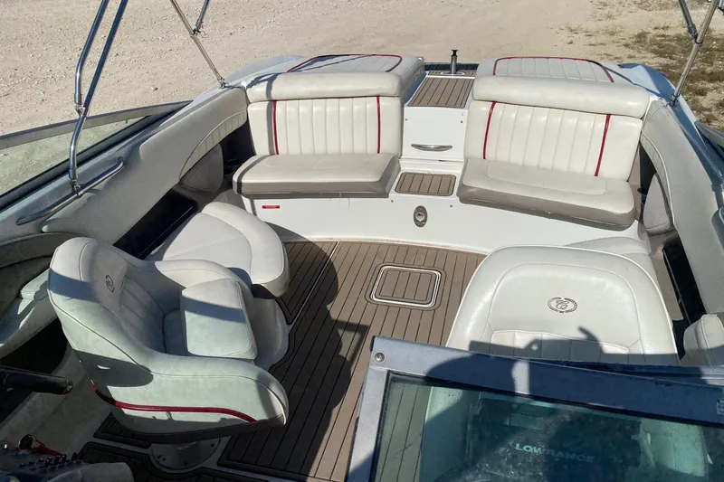 Slide: The Image of 2004 Crownline 250 CR boat interior with white seating and wood flooring. - 11